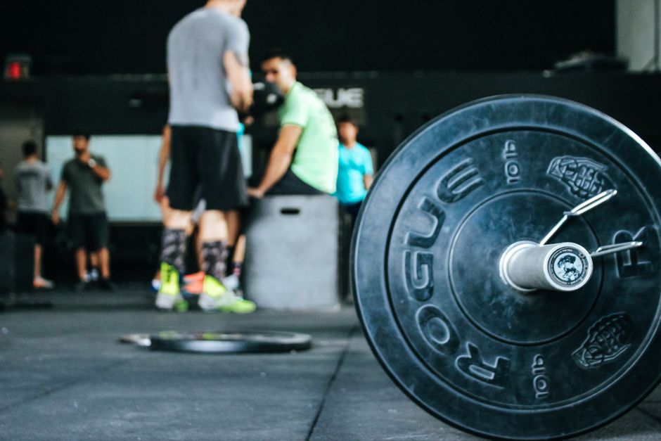 woman pushing weight plate on gym floor